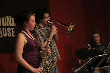 two people playing saxaphone and trombone together