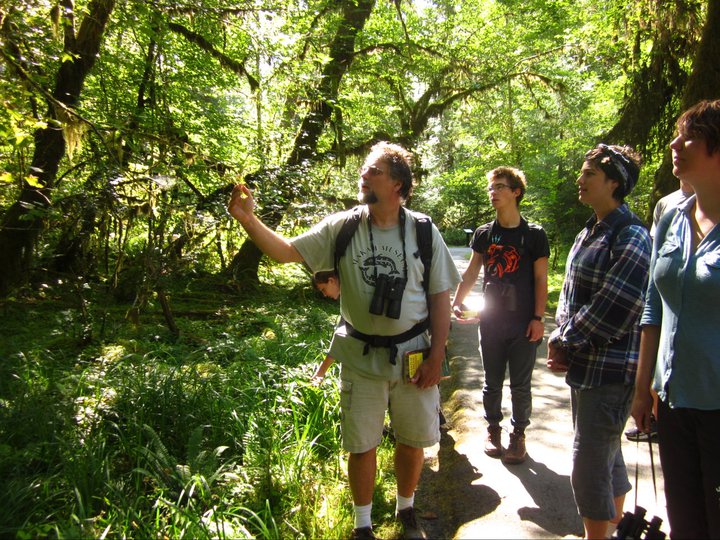 professor and students in the green forest examining a treel